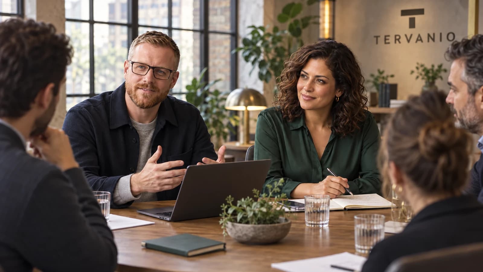 Elias Korven and Sienna Rovell leading a small roundtable discussion with fictional founders in Berlin.