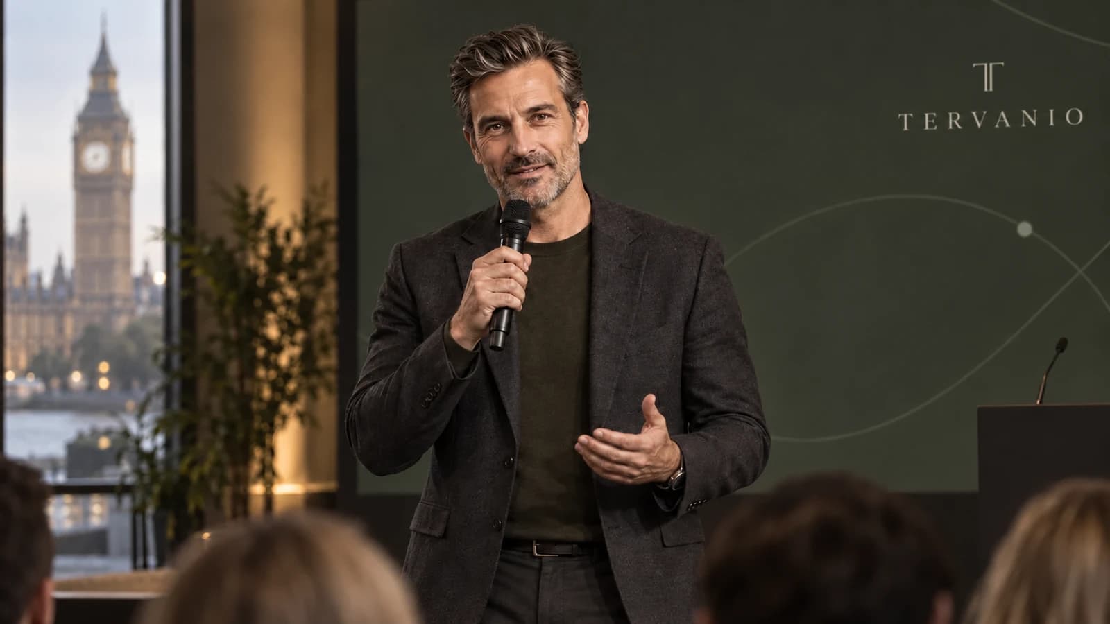 Adrian Vossmere speaking onstage to an audience at the fictional TERVANIO Open Systems Summit in London.